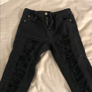 Black ripped jeans all down the front of the legs